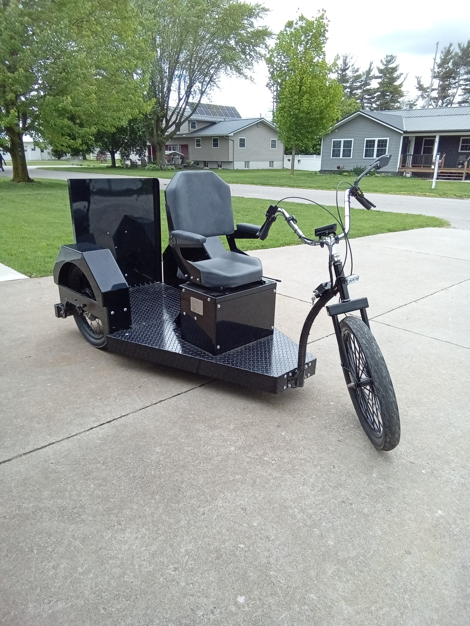 Black Drive-On trike with a driver seat and rear wheelchair position